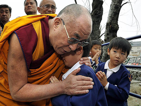 Il Dalai Lama abbraccia un bambino giapponese