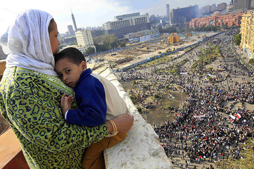 Una madre col figlio guarda piazza Tahrir